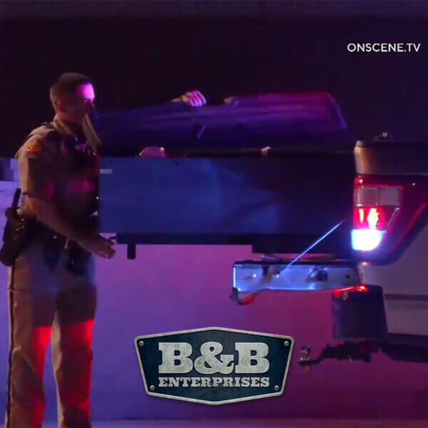 officer using an extended tactical extraction unit in the back of a truck.